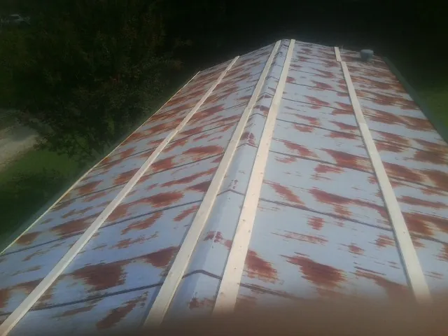 Rusted metal roof panels with new wood purlins before replacement — Storm Damage Roof Repair in Loysville by Roofing Brothers