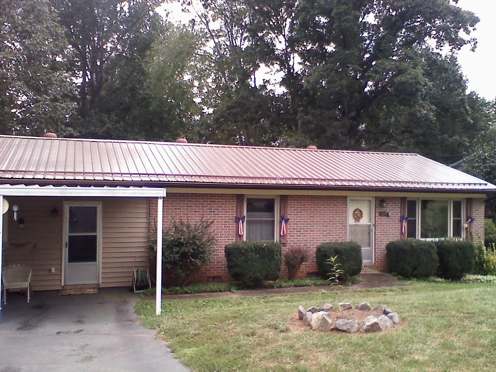 Bronze metal roof and carport on a brick ranch home — Roof Repair work by our crew in Loysville